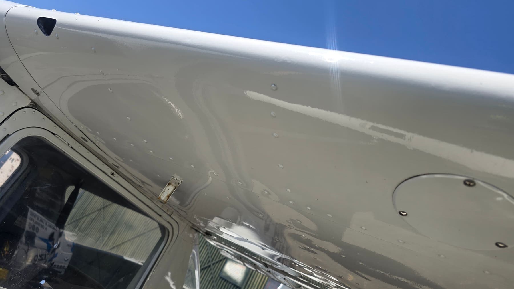Deep wet-look gloss on a freshly detailed aircraft wing against a blue sky