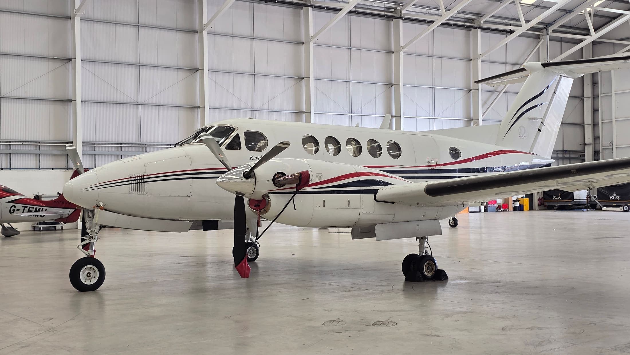 A Beechcraft King Air B200 in the hangar after a full exterior clean, nose to tail